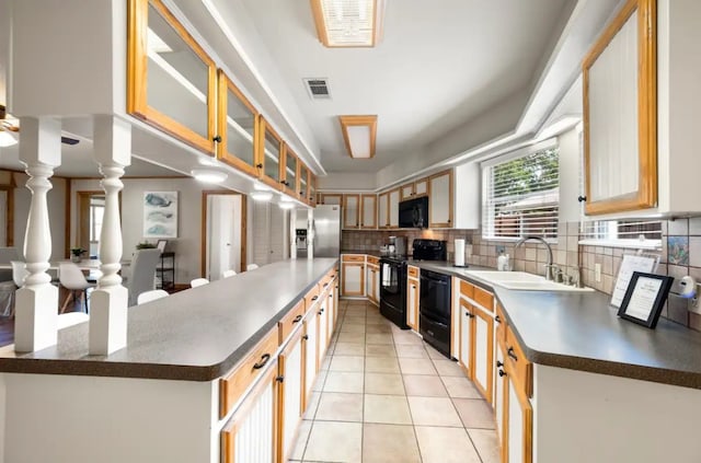 kitchen featuring light tile flooring, tasteful backsplash, sink, and black appliances