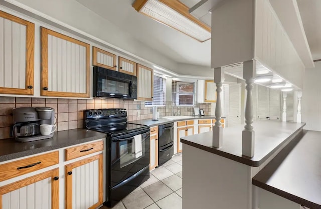 kitchen featuring backsplash, sink, light tile flooring, and black appliances