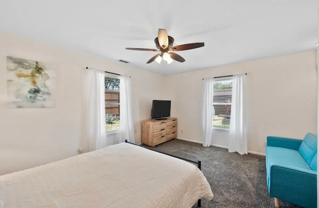 carpeted bedroom featuring multiple windows and ceiling fan