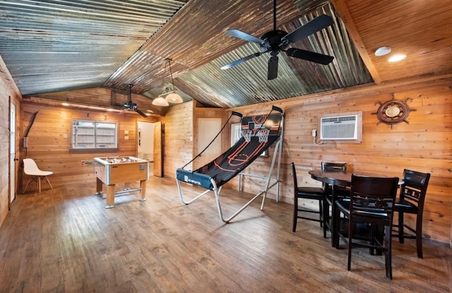 rec room with ceiling fan, hardwood / wood-style floors, vaulted ceiling, and an AC wall unit