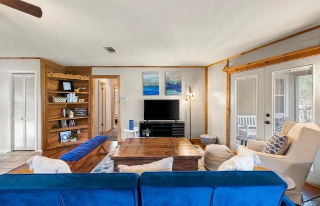 tiled living room featuring french doors and ceiling fan