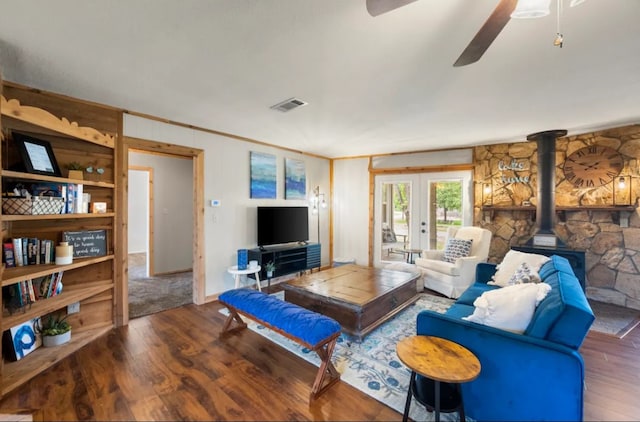 living room featuring french doors, ceiling fan, hardwood / wood-style flooring, and a wood stove