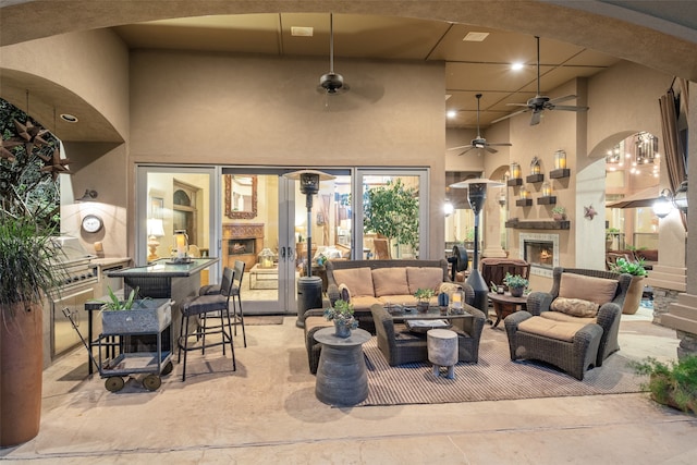 view of patio / terrace featuring an outdoor living space with a fireplace and ceiling fan