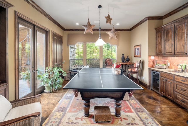 recreation room featuring sink, beverage cooler, and ornamental molding