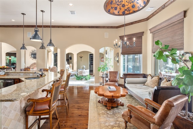 living room featuring sink, a chandelier, dark hardwood / wood-style floors, and ornamental molding