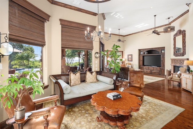 living room with hardwood / wood-style floors, ceiling fan with notable chandelier, and ornamental molding