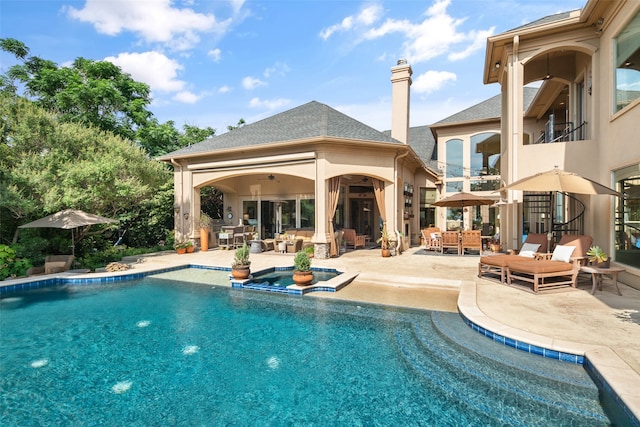 view of pool with outdoor lounge area, a patio area, and an in ground hot tub