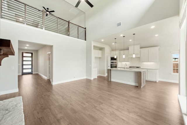 empty room with a wealth of natural light, lofted ceiling, and hardwood / wood-style flooring