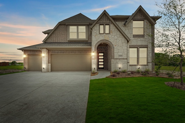 view of front of house with a garage and a yard