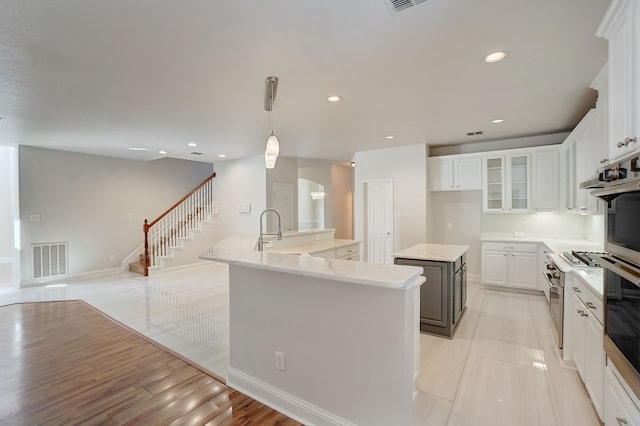 kitchen with a kitchen island, tasteful backsplash, decorative light fixtures, and white cabinets