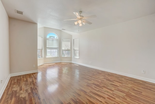 spare room featuring wood-type flooring, ceiling fan, and vaulted ceiling