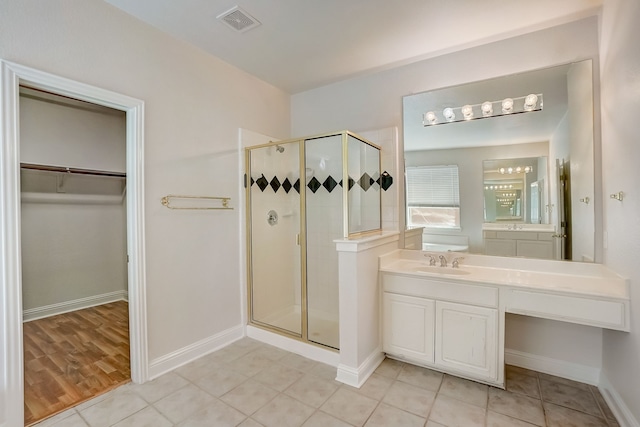 bathroom with walk in shower, vanity, and hardwood / wood-style flooring