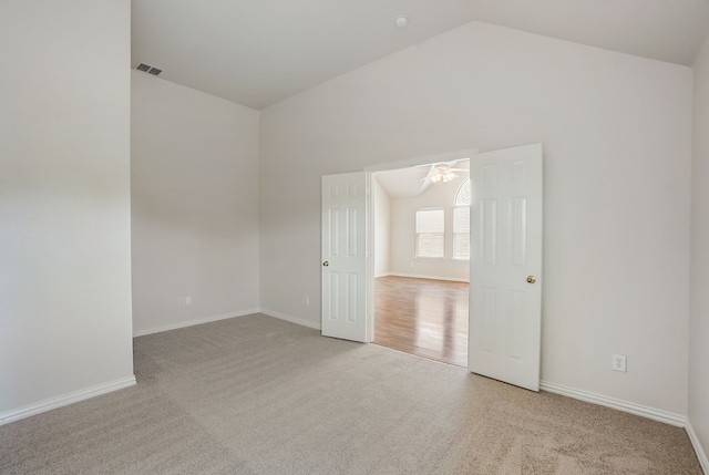 unfurnished room featuring vaulted ceiling, ceiling fan, and carpet floors