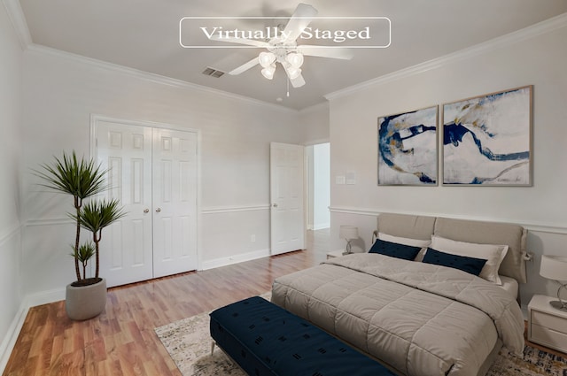 bedroom with wood-type flooring, ceiling fan, crown molding, and a closet