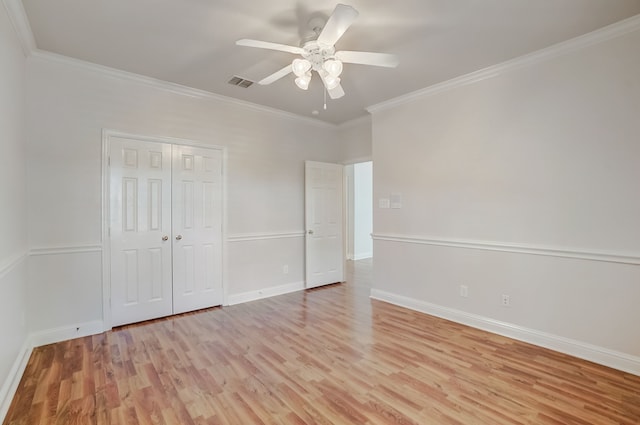 unfurnished bedroom featuring crown molding, a closet, light hardwood / wood-style floors, and ceiling fan