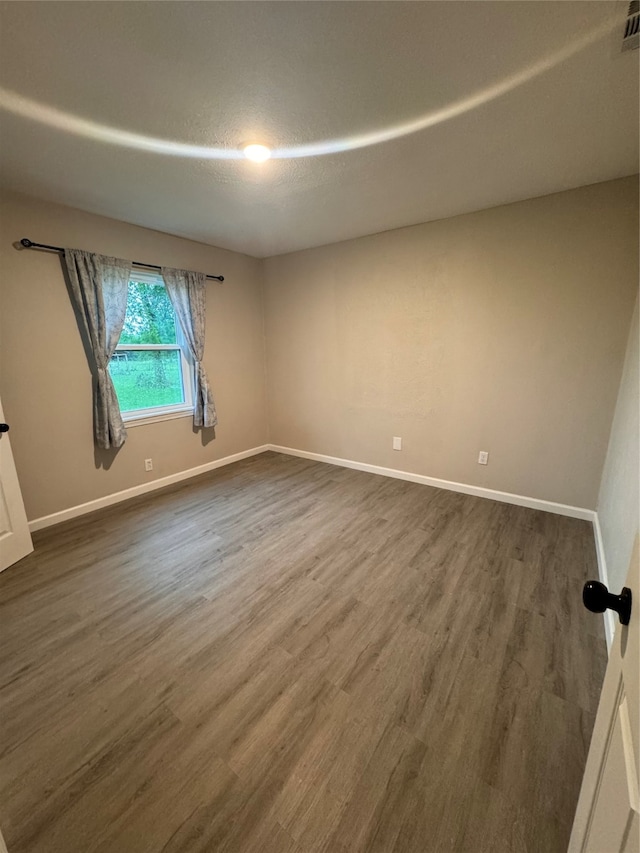 unfurnished room with dark wood-type flooring