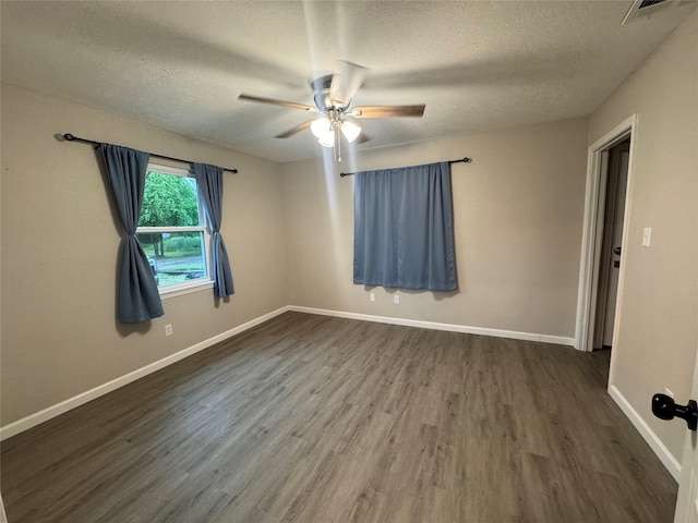 empty room featuring dark hardwood / wood-style floors, ceiling fan, and a textured ceiling