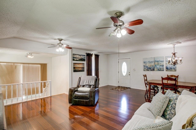 living room featuring ceiling fan with notable chandelier, a textured ceiling, and dark hardwood / wood-style flooring