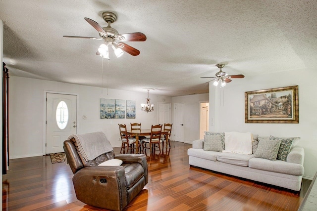 living room featuring ceiling fan with notable chandelier, a textured ceiling, and dark hardwood / wood-style flooring