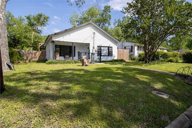 rear view of house featuring a lawn