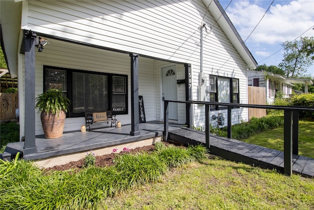 entrance to property featuring a yard and a porch