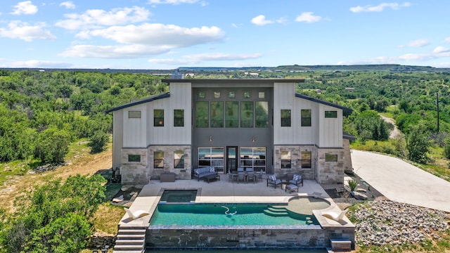 back of house featuring a swimming pool with hot tub, an outdoor living space, and a patio area