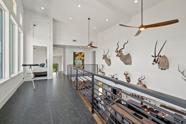 hall featuring beam ceiling and high vaulted ceiling