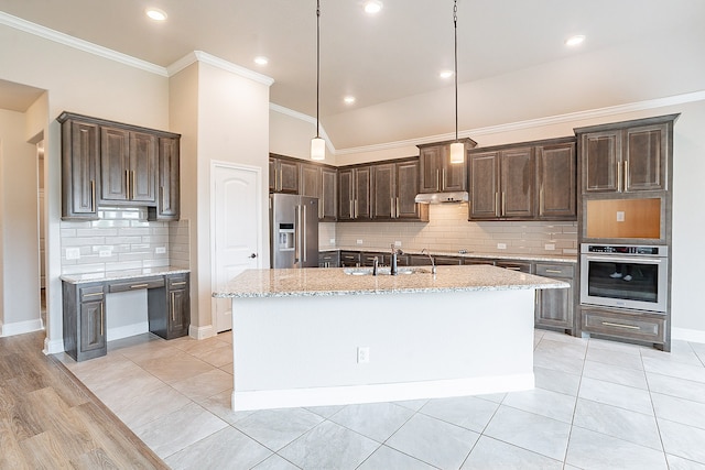 kitchen with appliances with stainless steel finishes, backsplash, light hardwood / wood-style floors, a kitchen island with sink, and sink