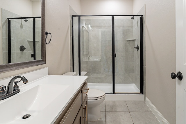 bathroom featuring a shower with door, large vanity, toilet, and tile flooring