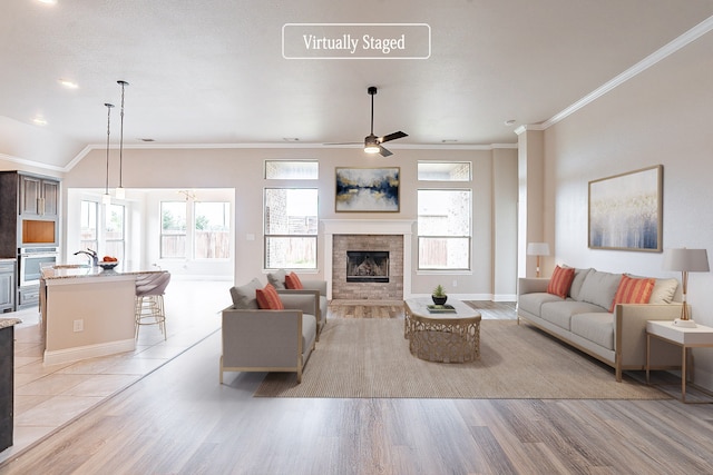 living room featuring ornamental molding, vaulted ceiling, ceiling fan, and light tile flooring