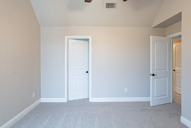 carpeted empty room featuring vaulted ceiling and ceiling fan