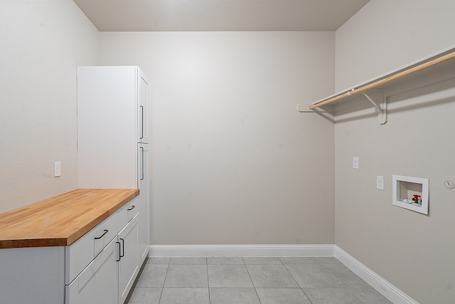 laundry room with light tile flooring, cabinets, and washer hookup