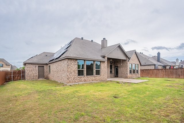 rear view of property featuring a patio area and a lawn