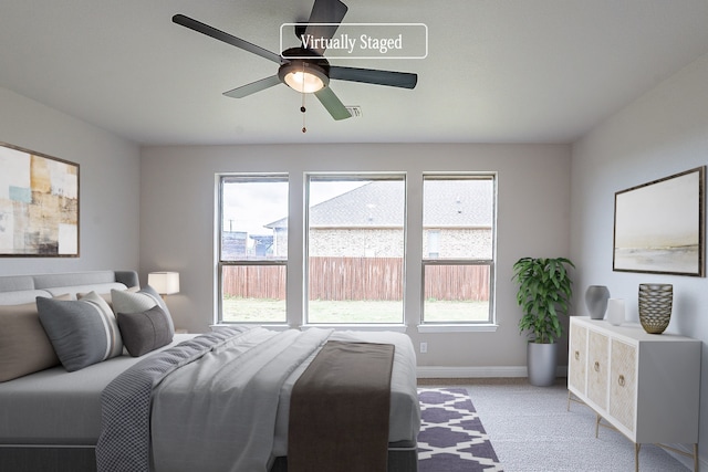 carpeted bedroom with multiple windows and ceiling fan