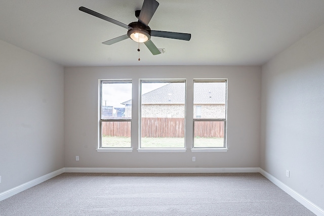 unfurnished room featuring plenty of natural light, ceiling fan, and carpet floors