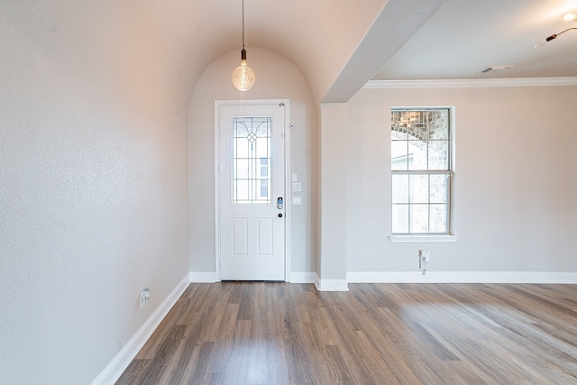 foyer entrance with wood-type flooring, lofted ceiling, and crown molding