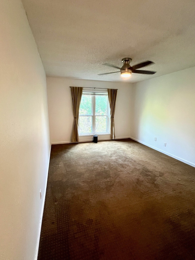 spare room with ceiling fan, carpet flooring, and a textured ceiling