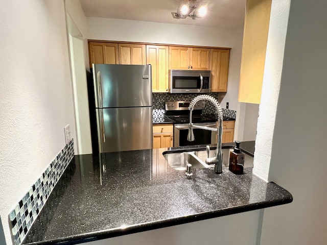 kitchen with sink, appliances with stainless steel finishes, and tasteful backsplash