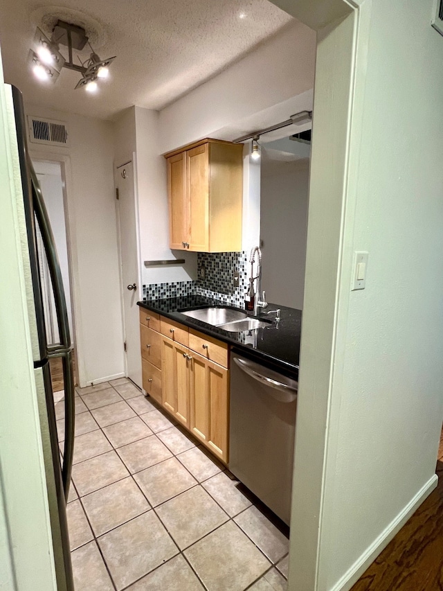 kitchen with light tile patterned floors, appliances with stainless steel finishes, backsplash, light brown cabinetry, and sink