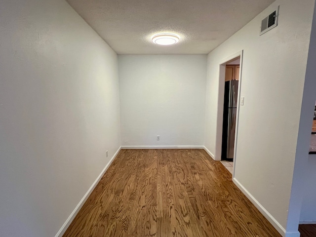 hallway featuring a textured ceiling and light wood-type flooring