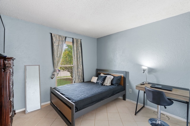 bedroom with a textured ceiling and light tile flooring