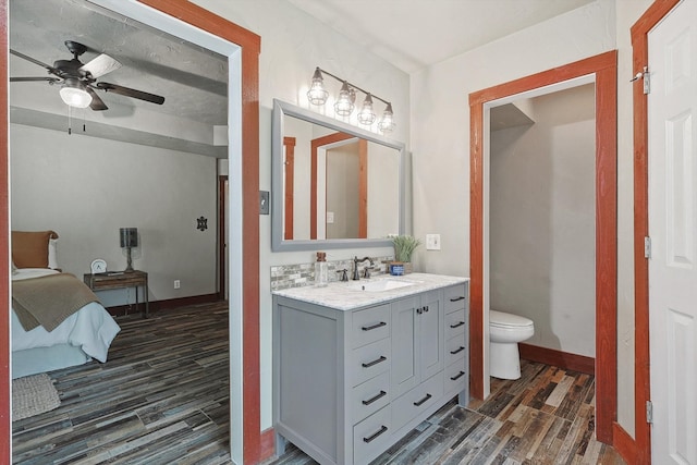 bathroom featuring hardwood / wood-style flooring, vanity, ceiling fan, and toilet