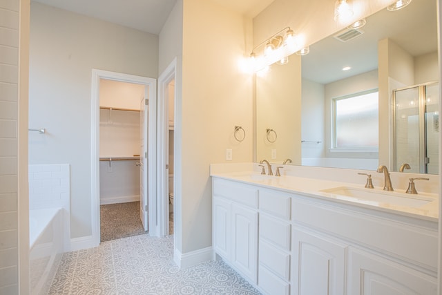 bathroom with dual sinks, tile flooring, vanity with extensive cabinet space, and plus walk in shower