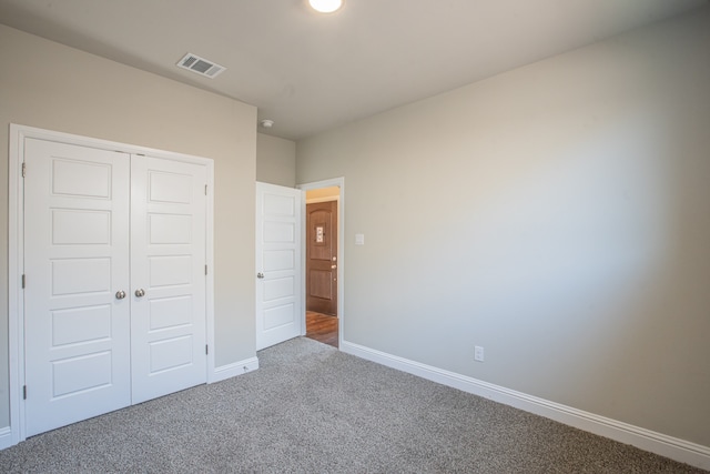 unfurnished bedroom featuring a closet and carpet flooring