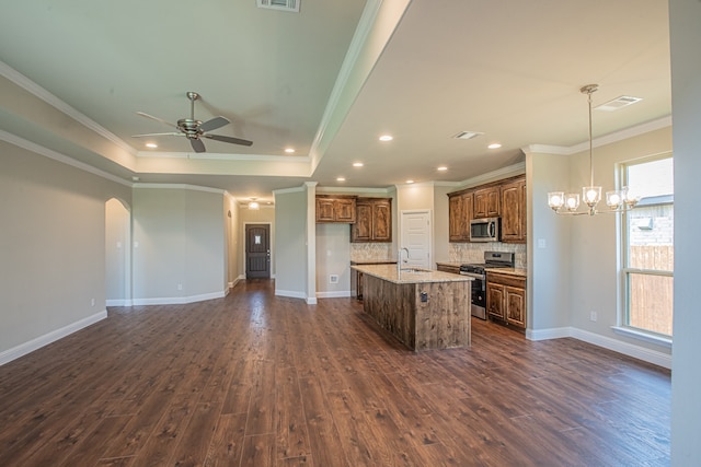 kitchen with stainless steel appliances, dark hardwood / wood-style flooring, an island with sink, and backsplash