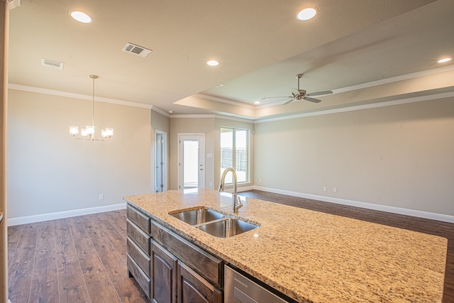 kitchen featuring crown molding, dark wood-type flooring, ceiling fan with notable chandelier, a tray ceiling, and sink