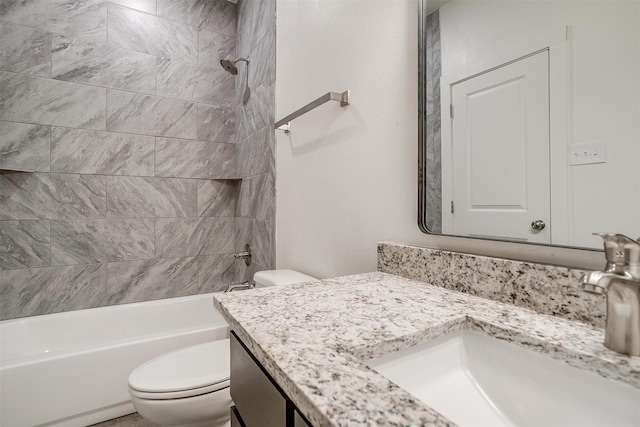 full bathroom with toilet, vanity, and tiled shower / bath