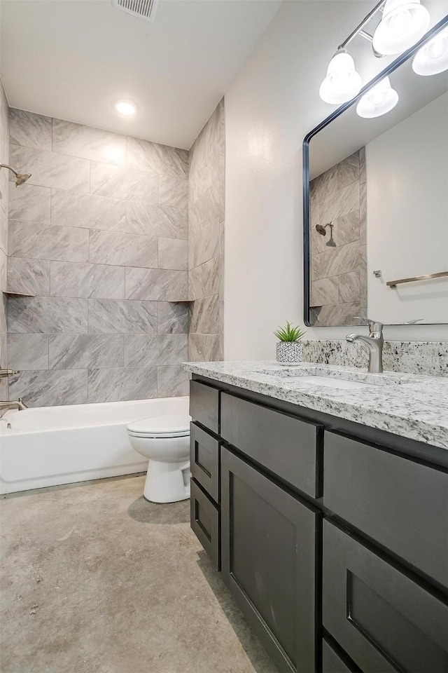 full bathroom featuring toilet, vanity, and tiled shower / bath