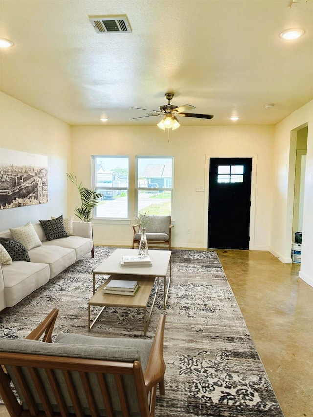 living room with ceiling fan and concrete floors