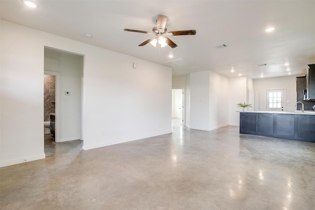 unfurnished living room with concrete floors, sink, and ceiling fan